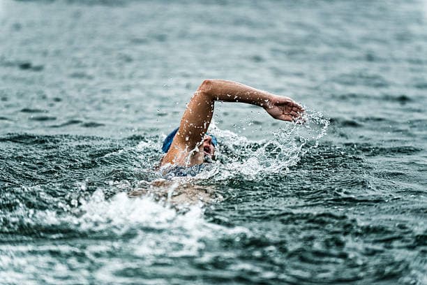 Swimmer in endurance event representing team coordination and information flow